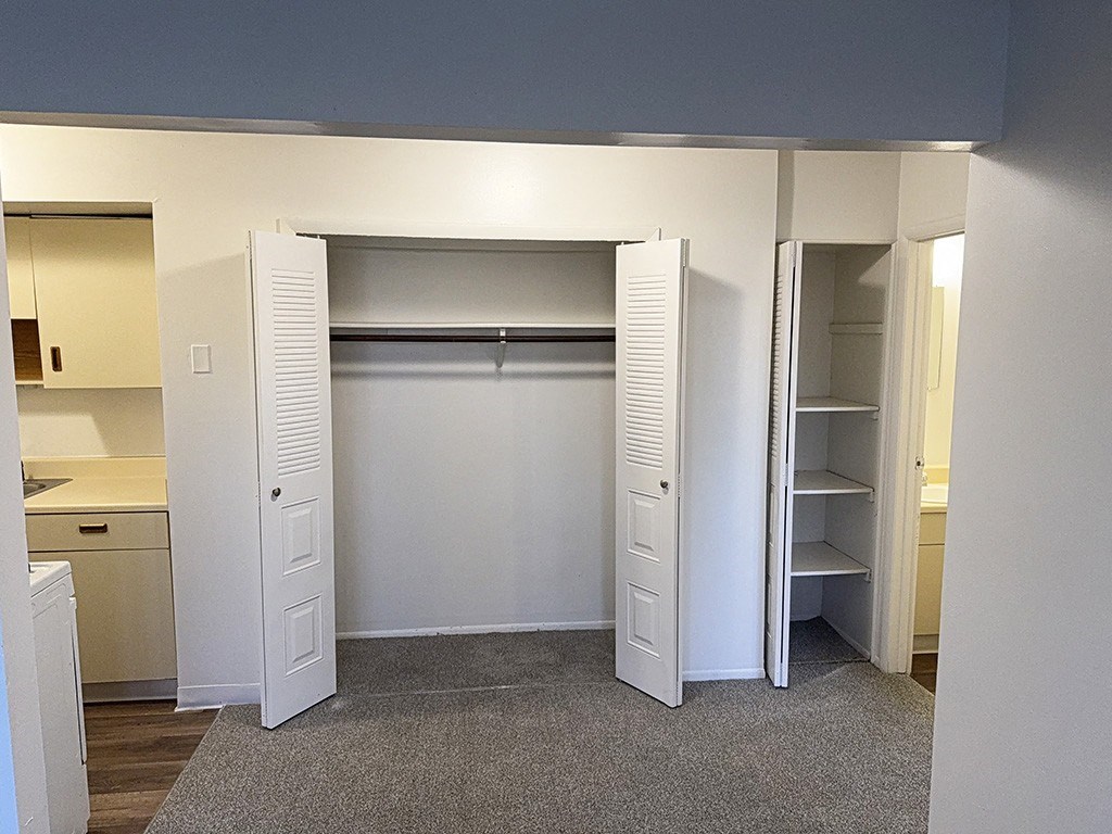 A dining room with a closet with a shelf and a linen closet at Waverly Park Apartments, Lansing