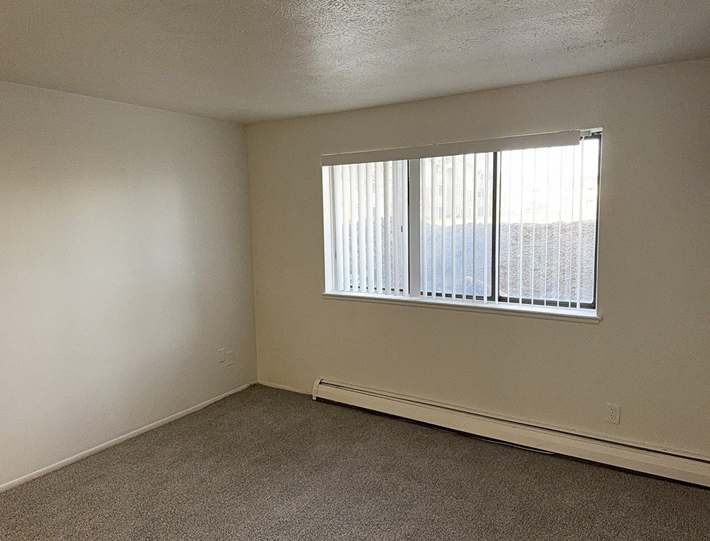 A garden style living room with a window and a carpeted floor at Waverly Park Apartments, Lansing