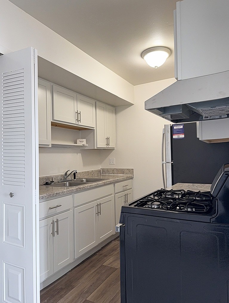 A kitchen with stainless steel appliances and white cabinets at Waverly Park Apartments, Lansing