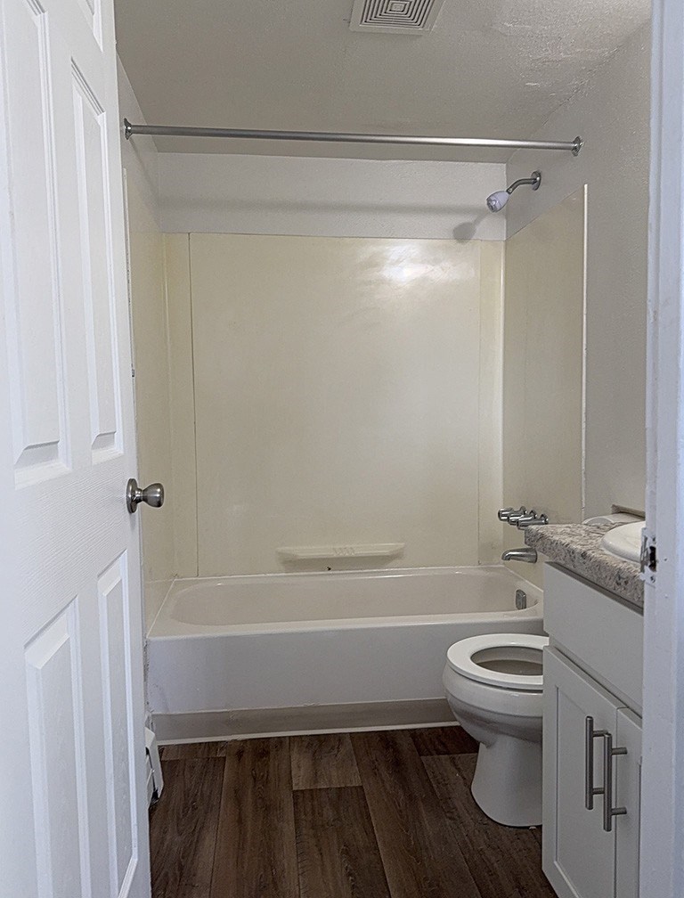 A bathroom with a toilet, sink, and bathtub at Waverly Park Apartments, Lansing