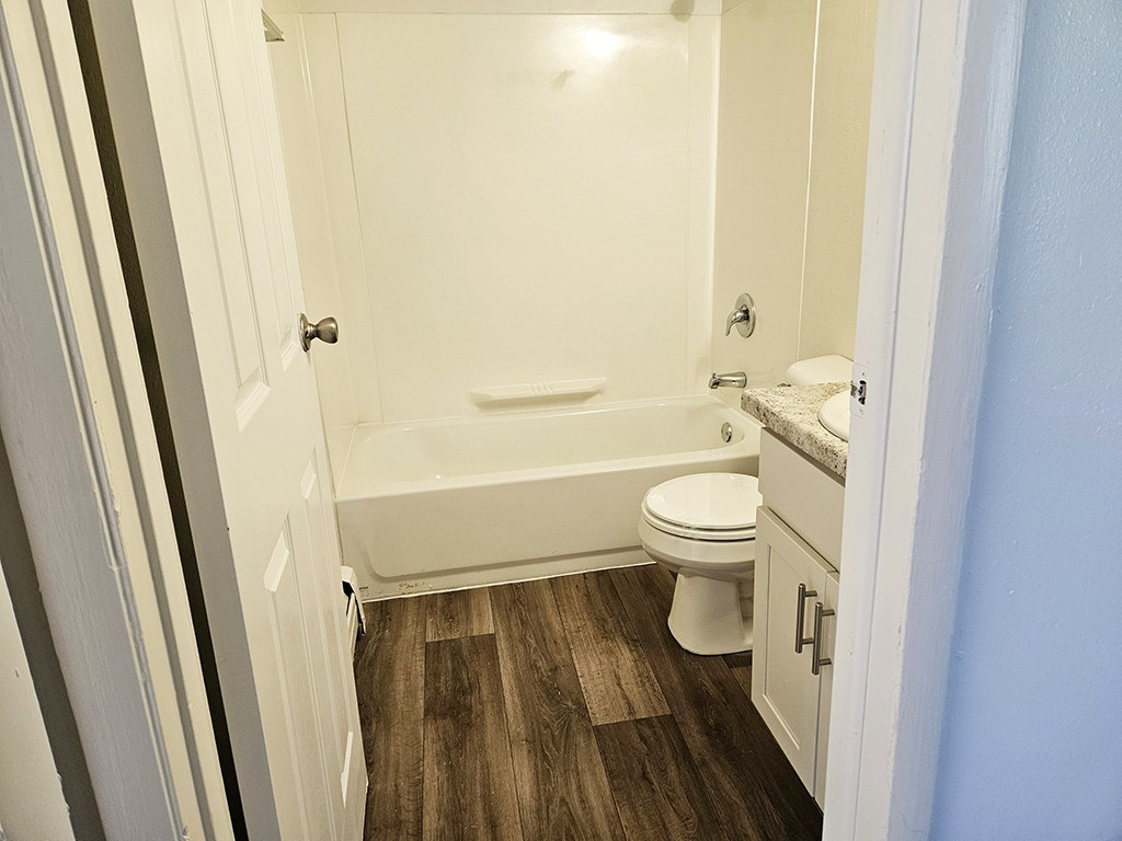 A bathroom with a toilet, sink, and bathtub at Waverly Park Apartments, Lansing