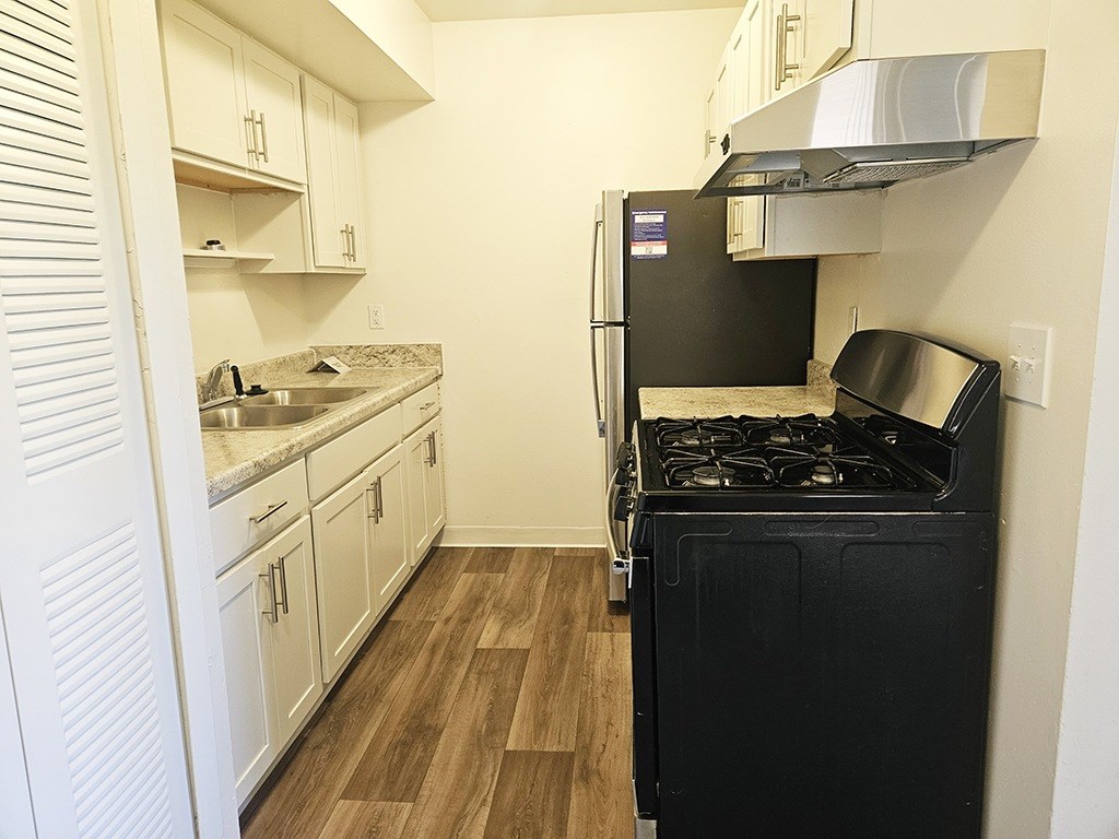 A kitchen with stainless steel appliances and white cabinetry at Waverly Park Apartments, Lansing