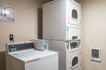 a laundry room with four washing machines and a washer and dryer at Rivers Edge Apartments, Michigan, 48327