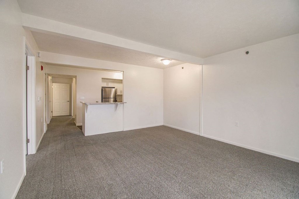 A living and dining room with a carpeted floor at West Hampton Park Apartments in Elkhorn, NE 68022