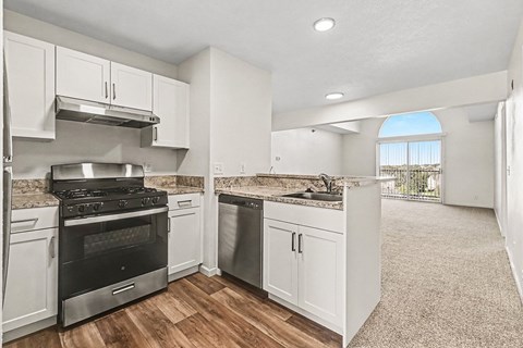 A kitchen with white cabinets and a black stove top oven.