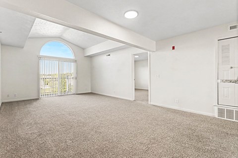 A spacious room with a carpeted floor and a skylight.