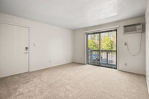 A room with a sliding glass door leading to a balcony.