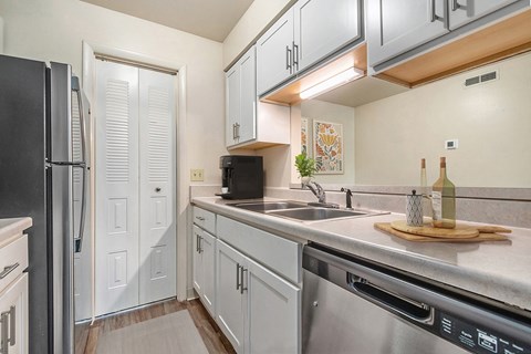 A kitchen with a black refrigerator and stainless steel appliances.
