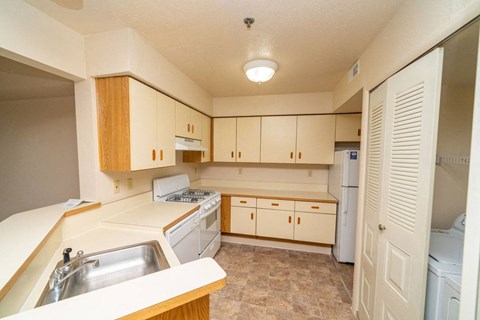 a kitchen with white cabinets and a sink and a refrigerator