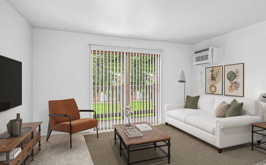 A living room with a white couch, a brown chair, and a coffee table at Wingate Apartments, Michigan