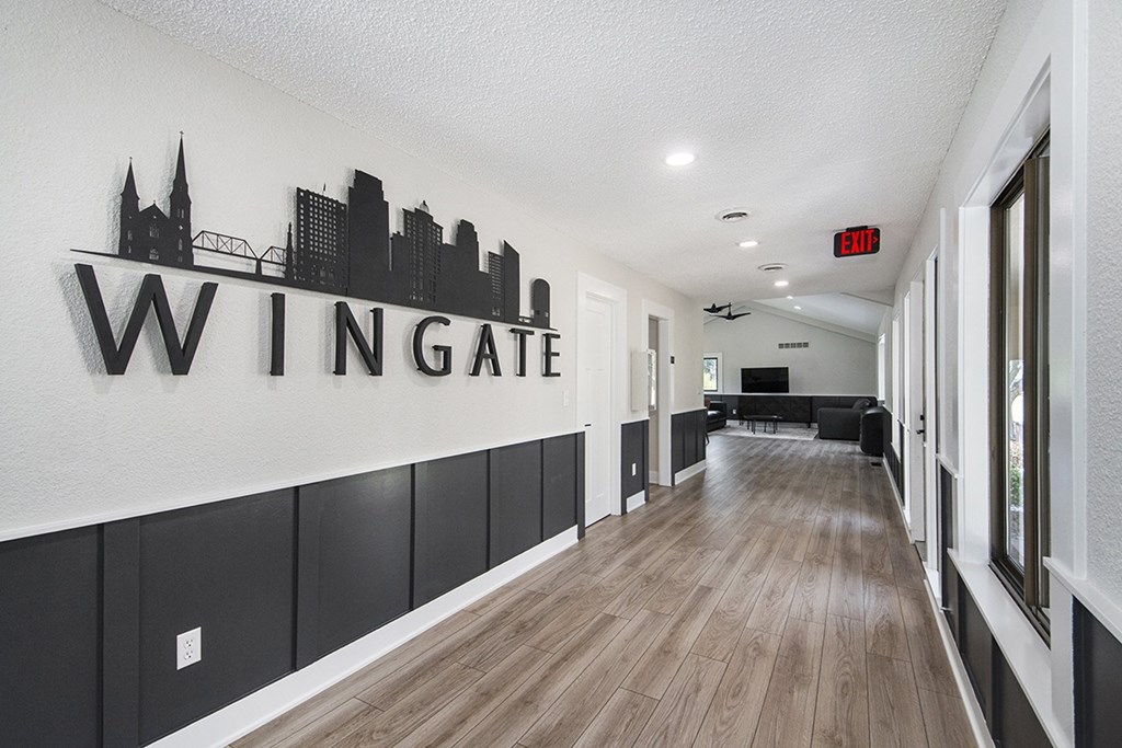 A hallway to the leasing office with a sign on the wall at Wingate Apartments, Kentwood