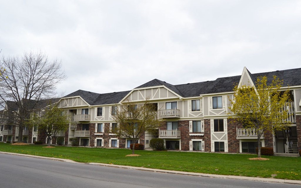A brick apartment building with green grass in front at Wingate Apartments, Kentwood, Michigan