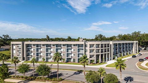 A large apartment complex with a parking lot in front.