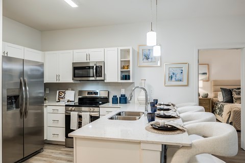 A modern kitchen with a stainless steel refrigerator, microwave, and oven.