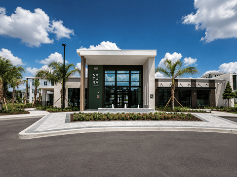 A modern building with a green sign that says NO PARKING.