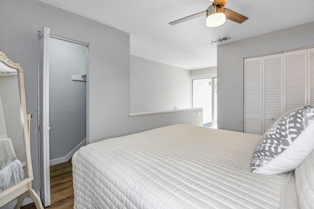 a bedroom with a large white bed and a closet