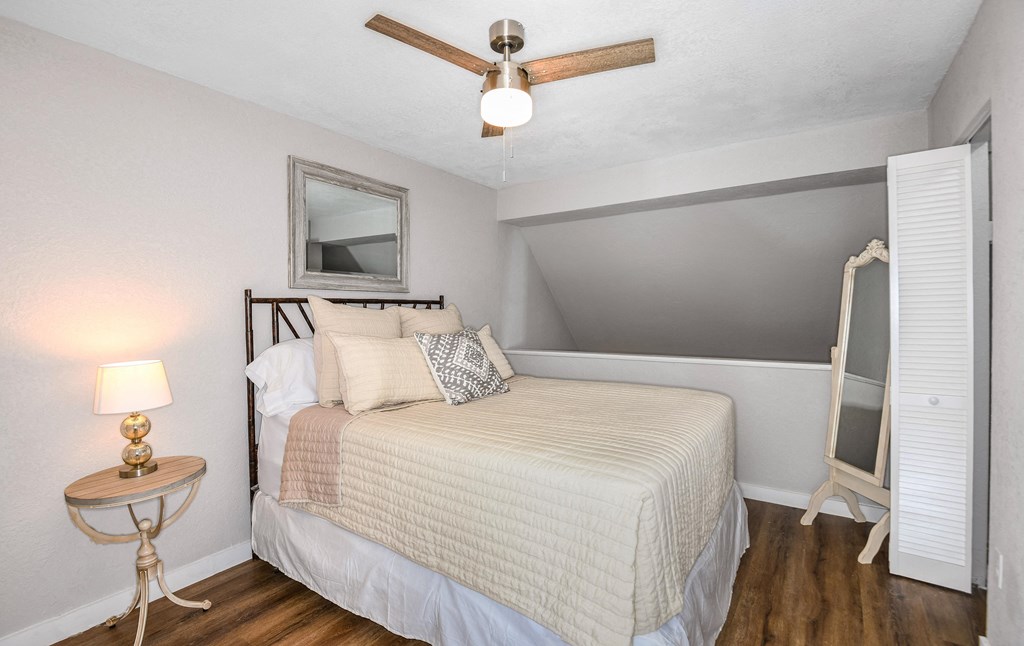 a bedroom with a bed and a ceiling fan