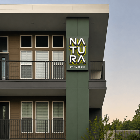 A modern building with a green column and a sign that reads "NATURA by MURBECK".