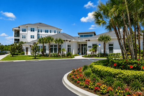 A large white building with a driveway in front of it.