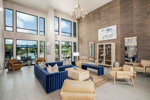 A living room with a blue couch and a chandelier.