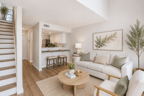 A living room with a white couch, a wooden coffee table, and a painting on the wall.