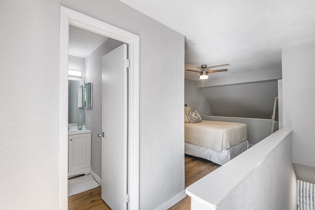 a bedroom with a bed and a ceiling fan