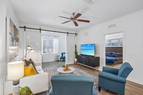 A living room with a blue chair and a white couch.