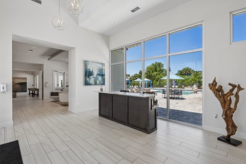 A modern house interior with a pool visible through the windows.
