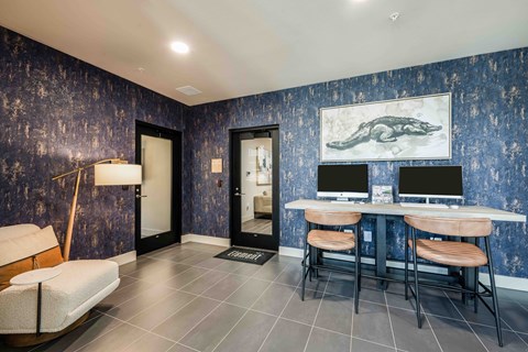 A room with a blue wallpaper and a painting of a crocodile on the wall.