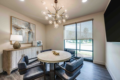 A modern dining room with a round table and chairs.