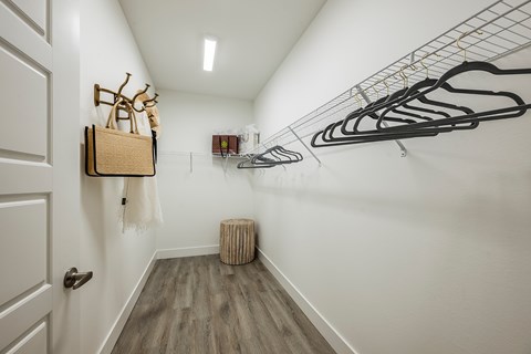 A hallway with a coat rack and a bench.