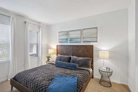 A bedroom with a large bed and a small table.