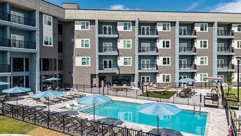 A large apartment complex with a pool and patio area.