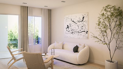 A living room with a white couch, a chair, a potted plant, and a painting on the wall.