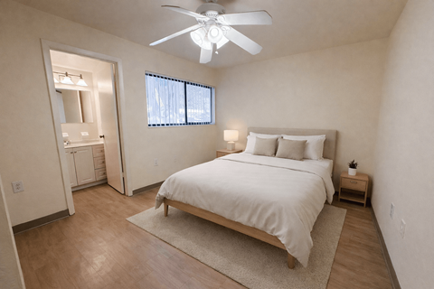 A bedroom with a bed, nightstand, and window.