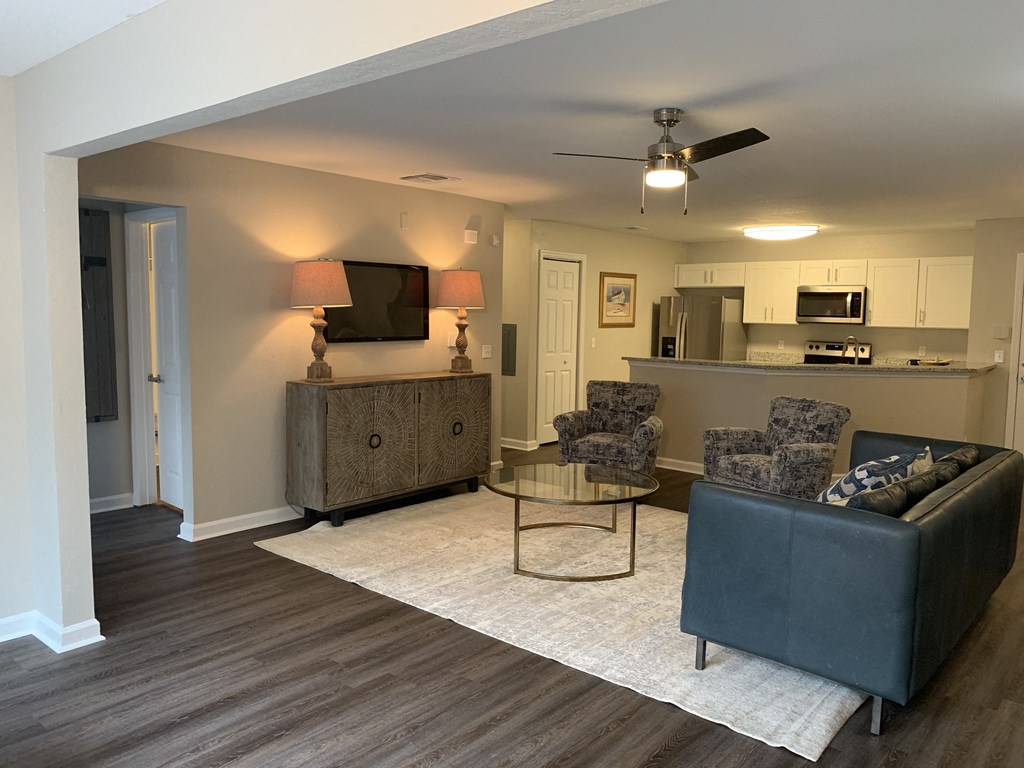 Compass living room with couch, and kitchen in background