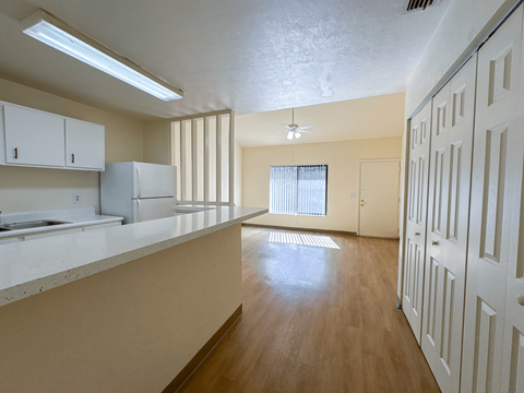 A kitchen with white cabinets and a refrigerator.