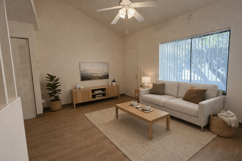 A living room with a white couch, a wooden coffee table, and a ceiling fan.