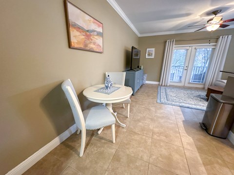 A dining room with a white table and chairs.