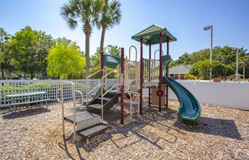 A playground with a green slide and a red and white structure.