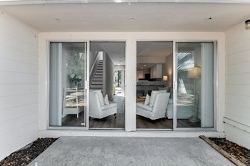 A white house with a glass door leading to a living room.