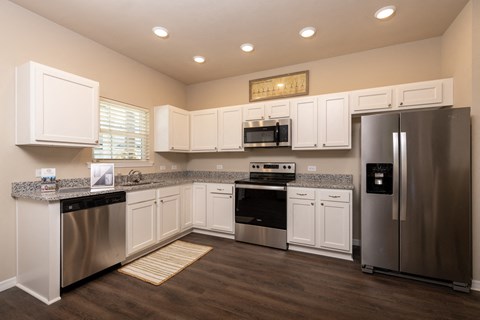 a kitchen with white cabinets and stainless steel appliances