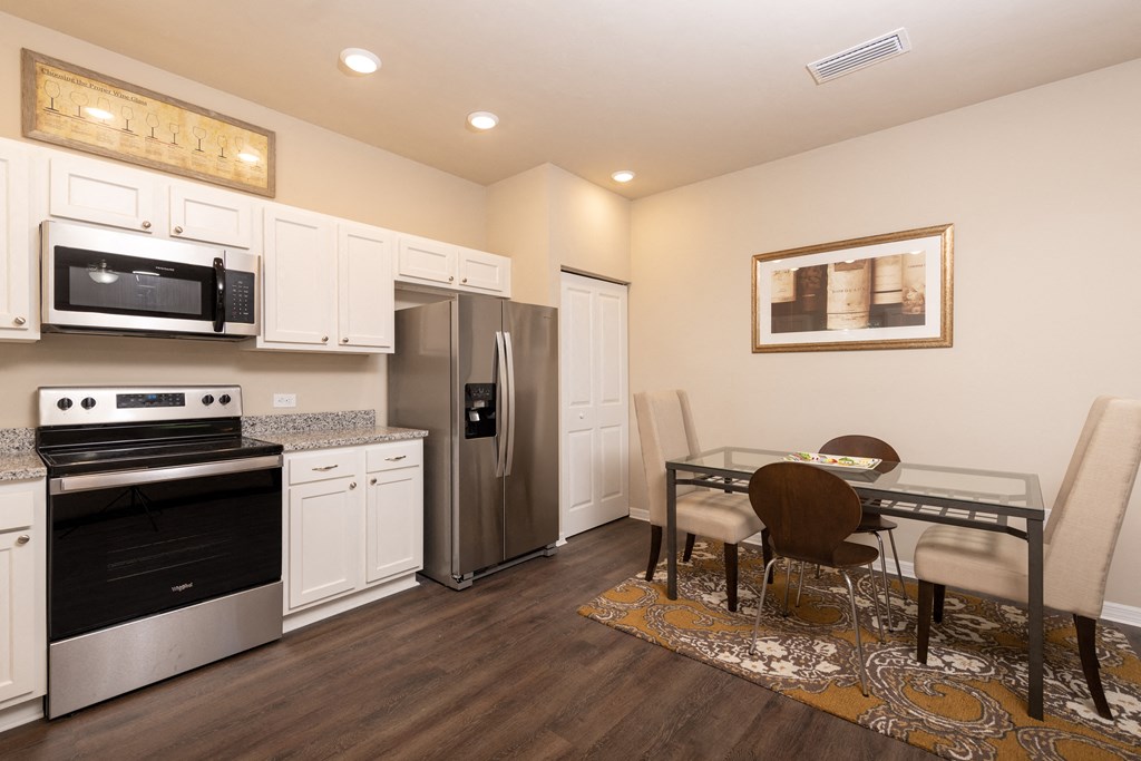 ktichen dining area, whit cabinets, canned lights and high ceilings