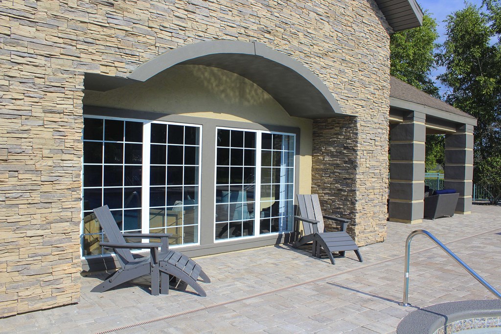 Back of clubhouse with pool deck and chairs