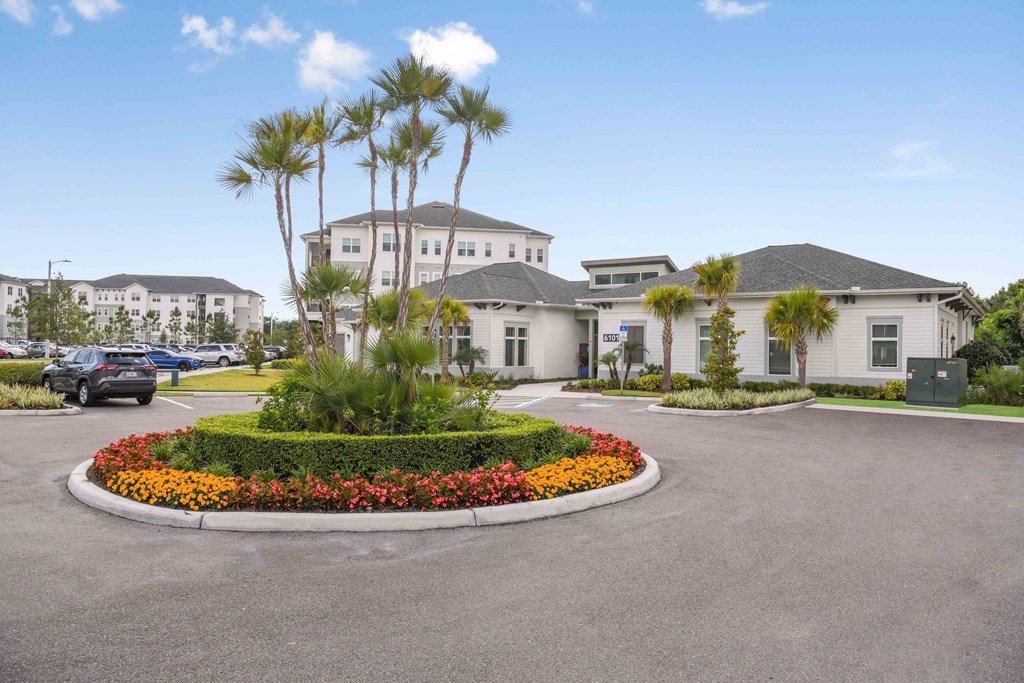a large parking lot with palm trees in front of a house