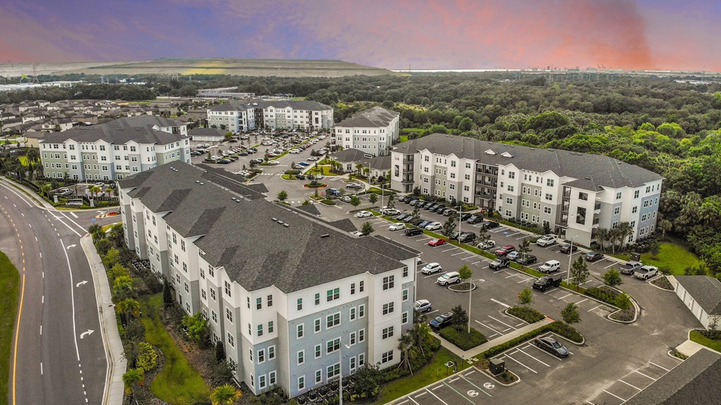 an aerial view of an apartment complex with cars parked in a parking lot
