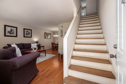 A living room with a couch and a staircase.