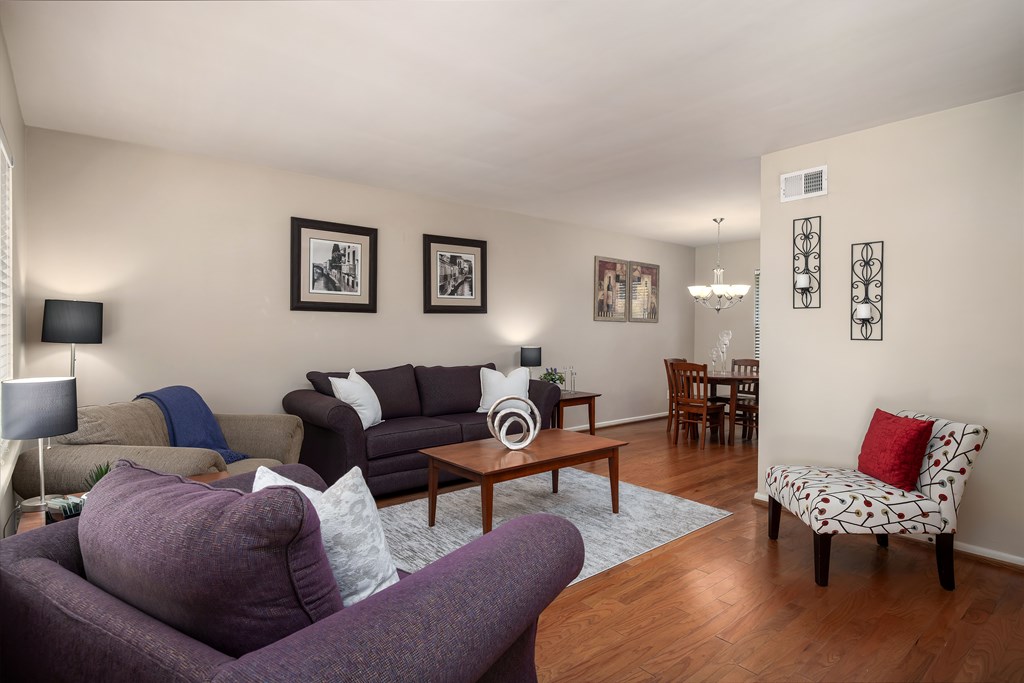 A living room with a purple couch and a wooden coffee table.