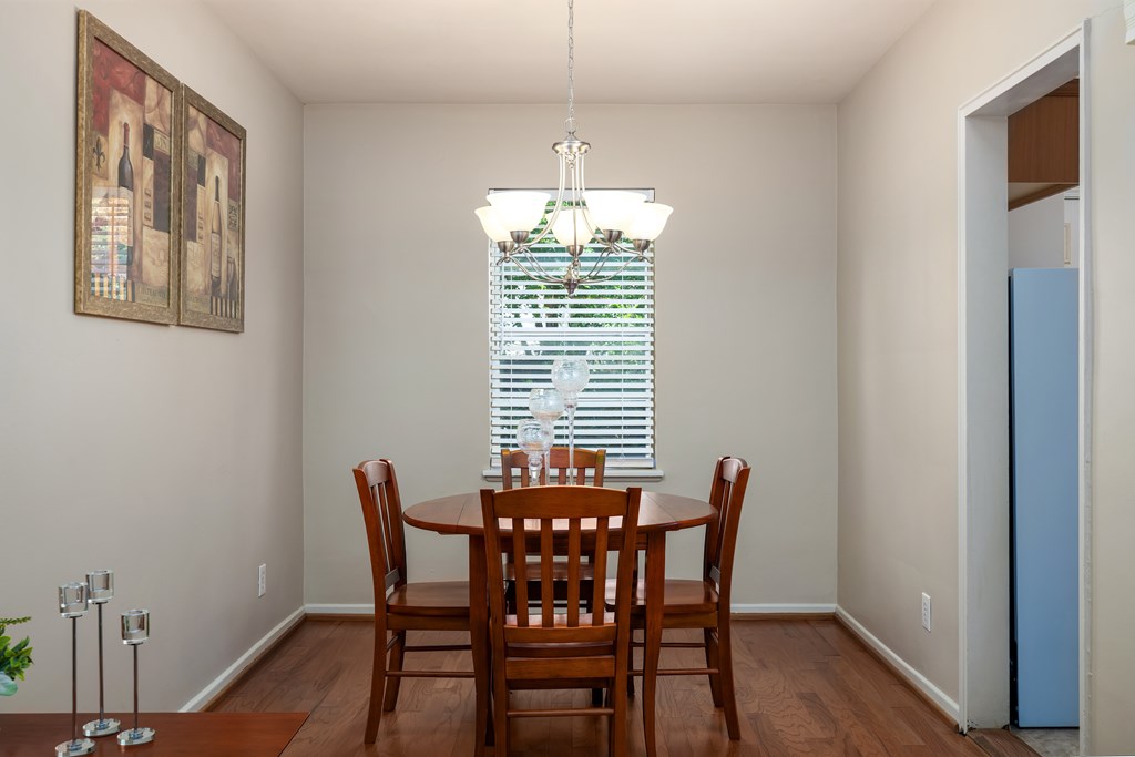 A dining room with a wooden table and chairs.