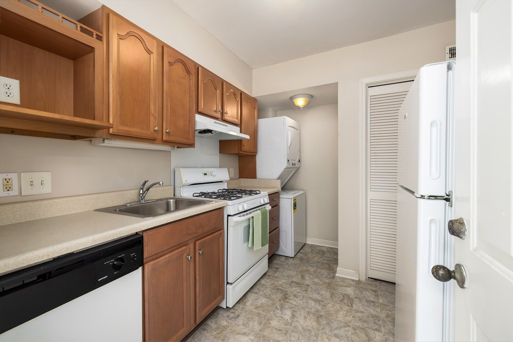 A kitchen with white appliances and wooden cabinets.